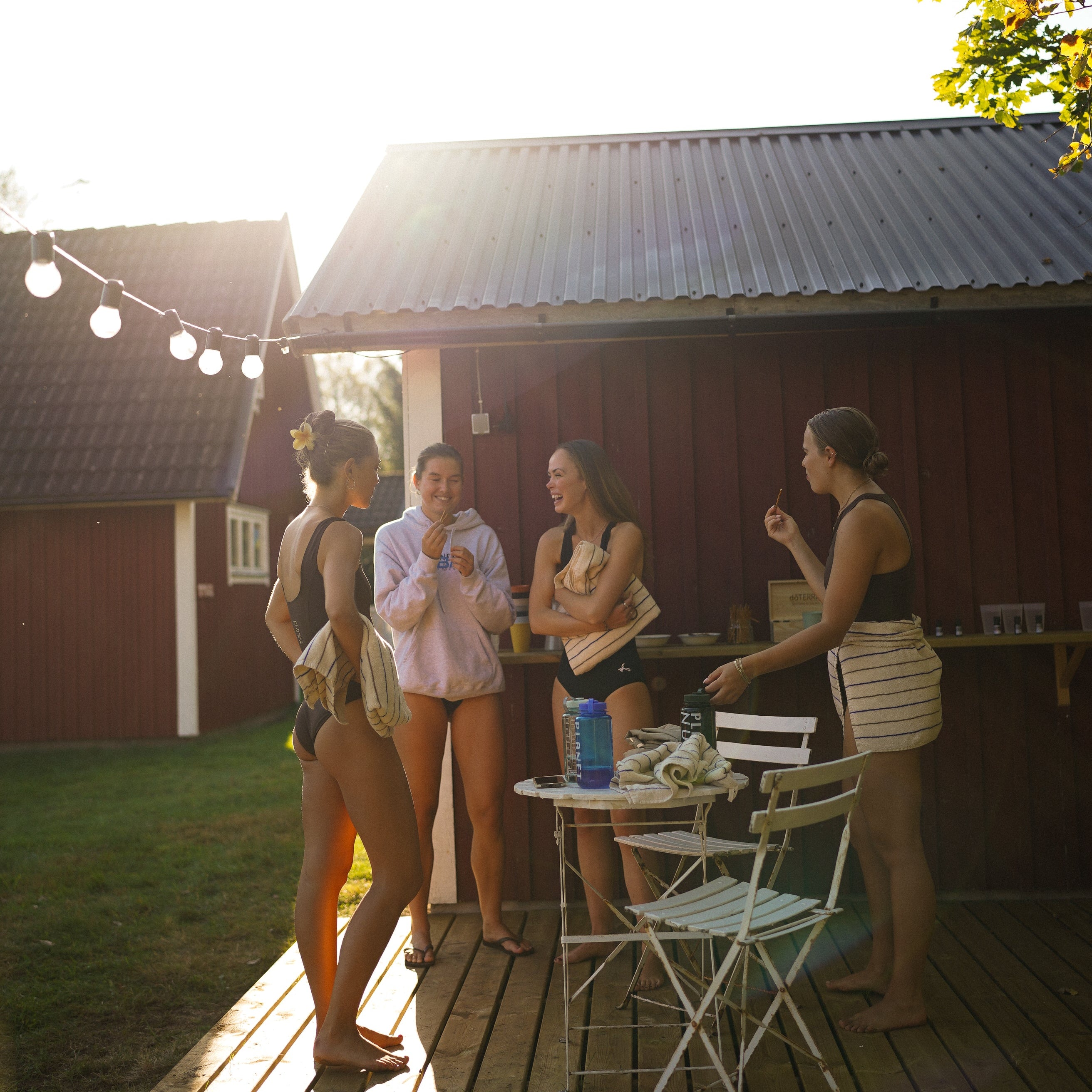 Group of women socializing on a wooden deck with a rustic building in the background